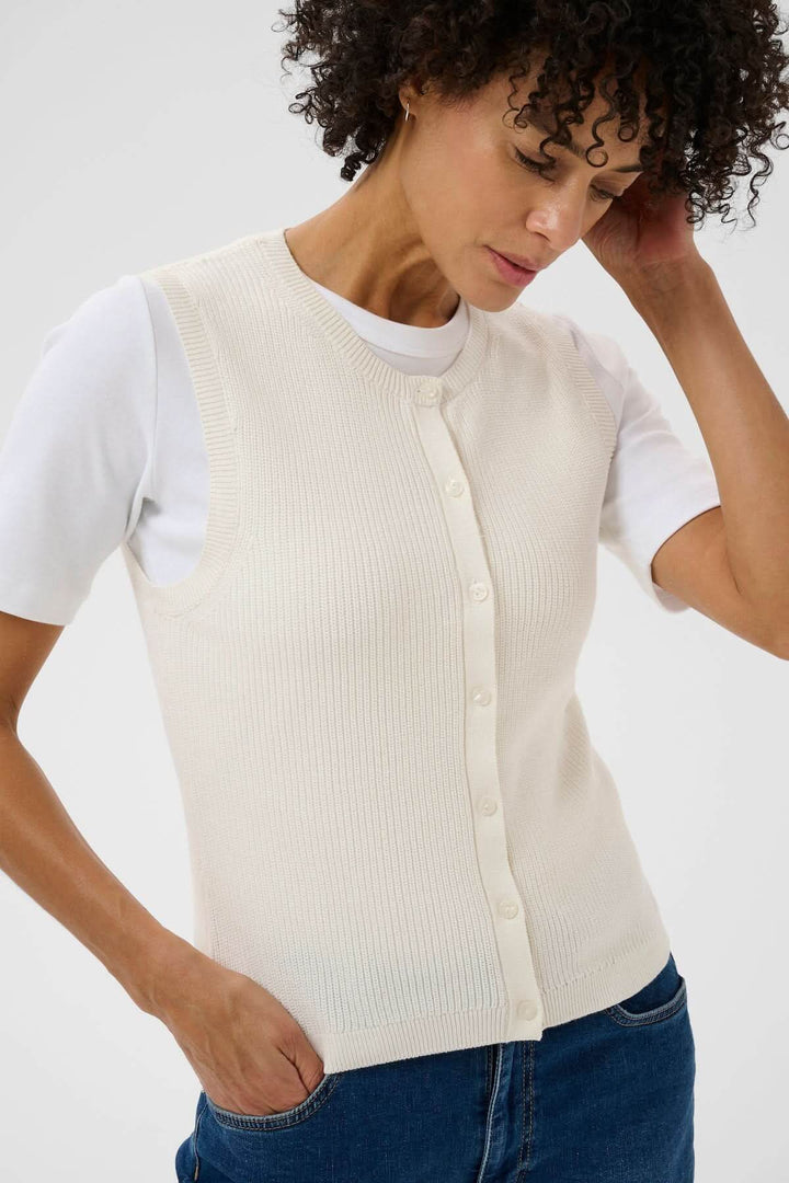 Femme portant la Veste de tricot Gemma sans manches, en maille fine avec une patte de boutonnage, coupe droite élégante et minimaliste.