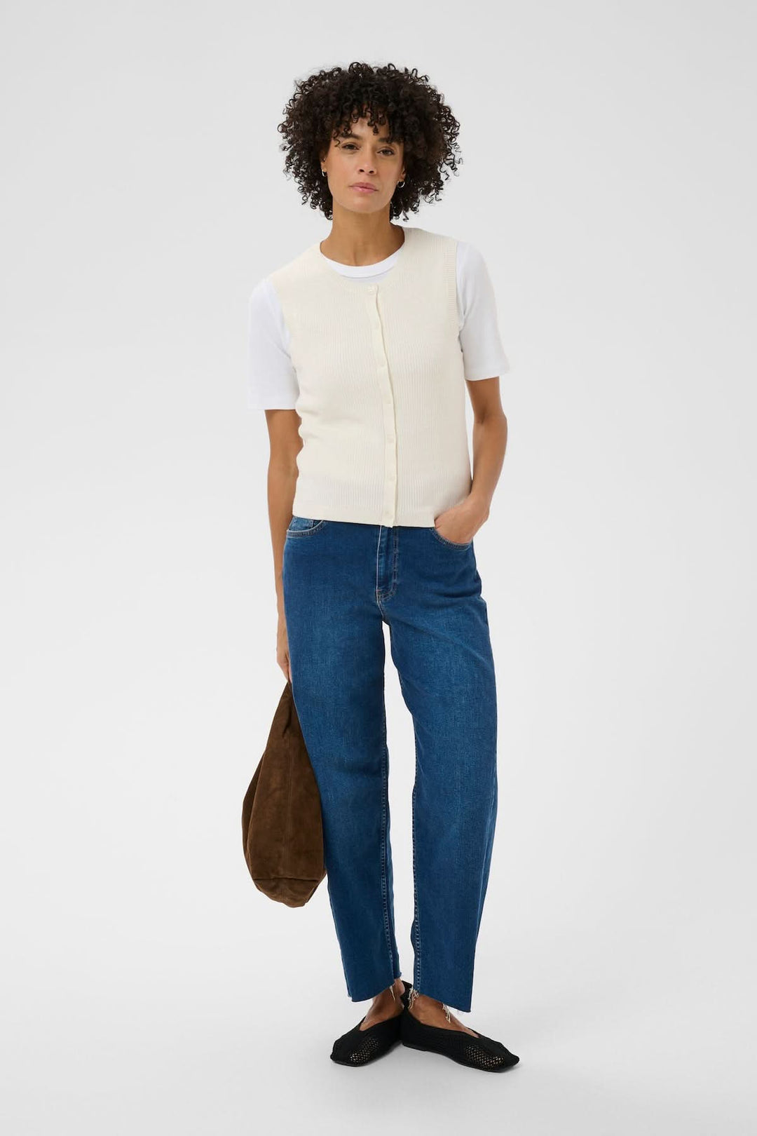 Femme portant la Veste de tricot Gemma sans manches, coupe droite minimaliste.