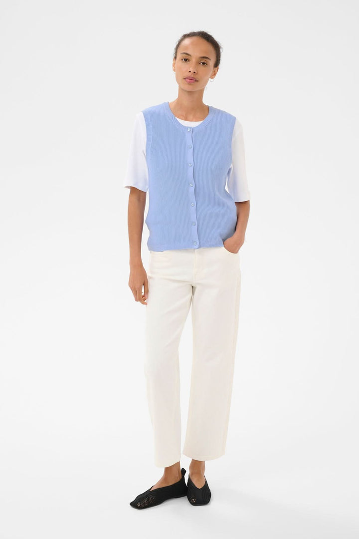 Veste de tricot Gemma en maille fine sans manches, coupe droite et encolure ronde, élégante et minimaliste, portée par une modèle féminine.