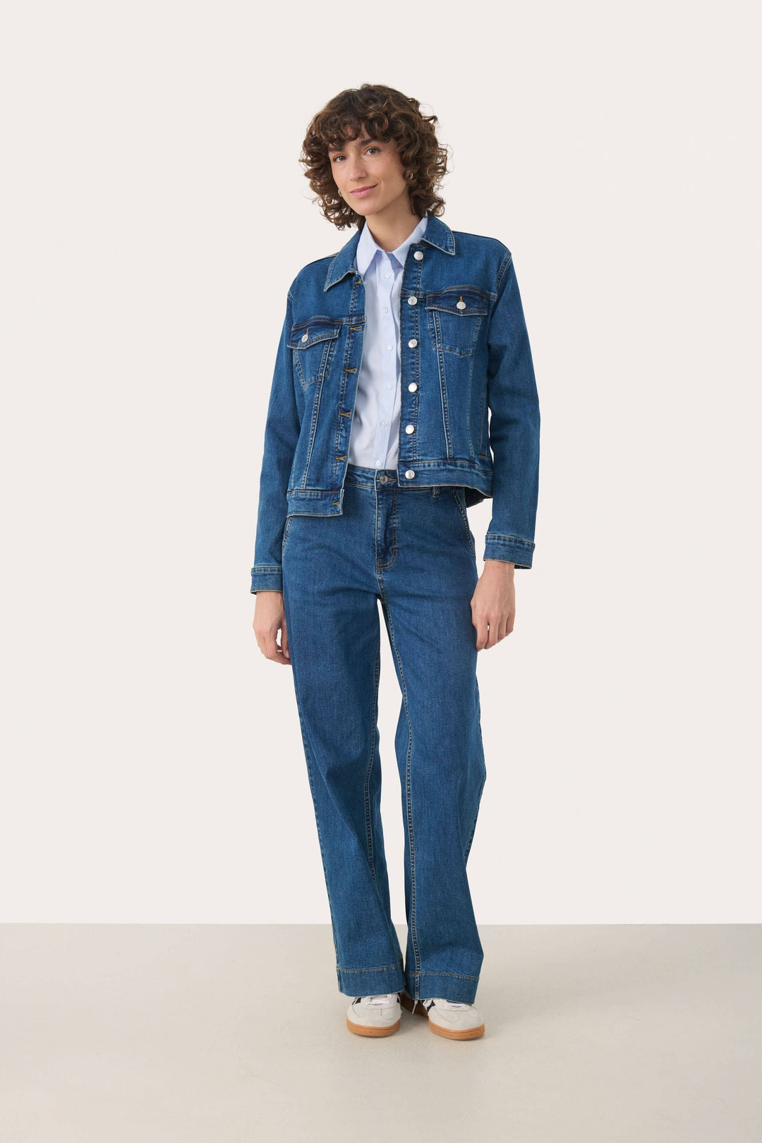 Veste en jeans Nicholia portée avec style, coupe droite et boutons métalliques, idéale pour un look denim coordonné ou habillé.