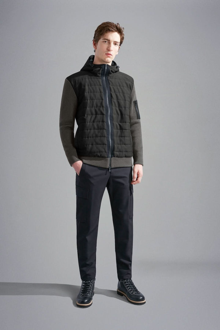 Homme portant une veste imperméable à capuchon Paul & Shark, élégante et fonctionnelle, avec pantalon noir.