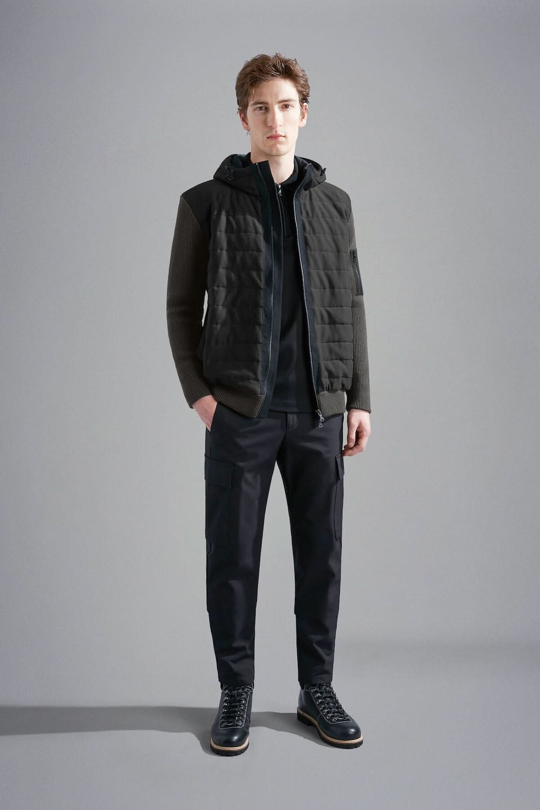 Homme portant une veste imperméable à capuchon Paul & Shark, idéale pour le froid, avec matelassage léger.