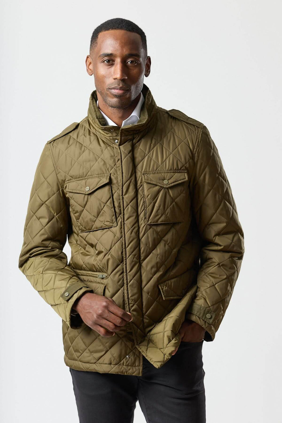 Homme portant une veste matelassée à capuche escamotable, idéale pour un look smart-casual, avec matelassage losange en vert olive.