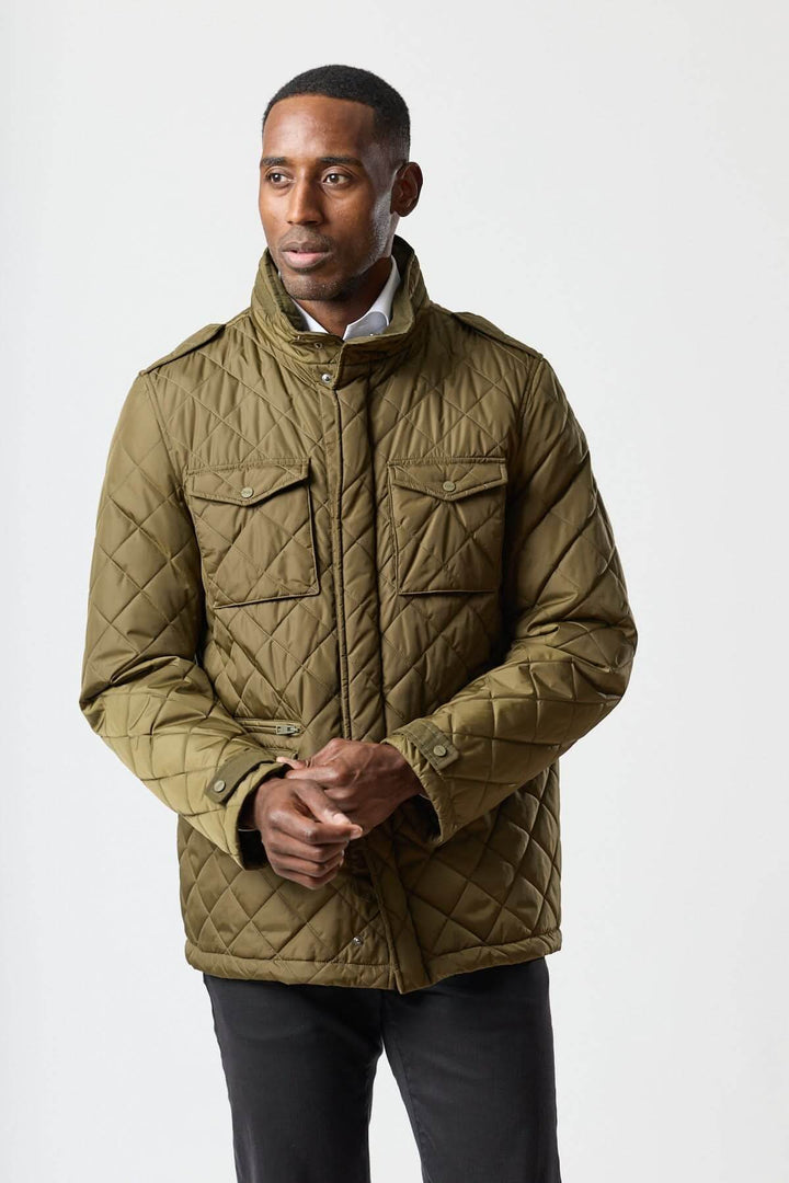 Homme portant une veste matelassée à capuche escamotable avec col montant et matelassage losange, idéale pour la mi-saison.
