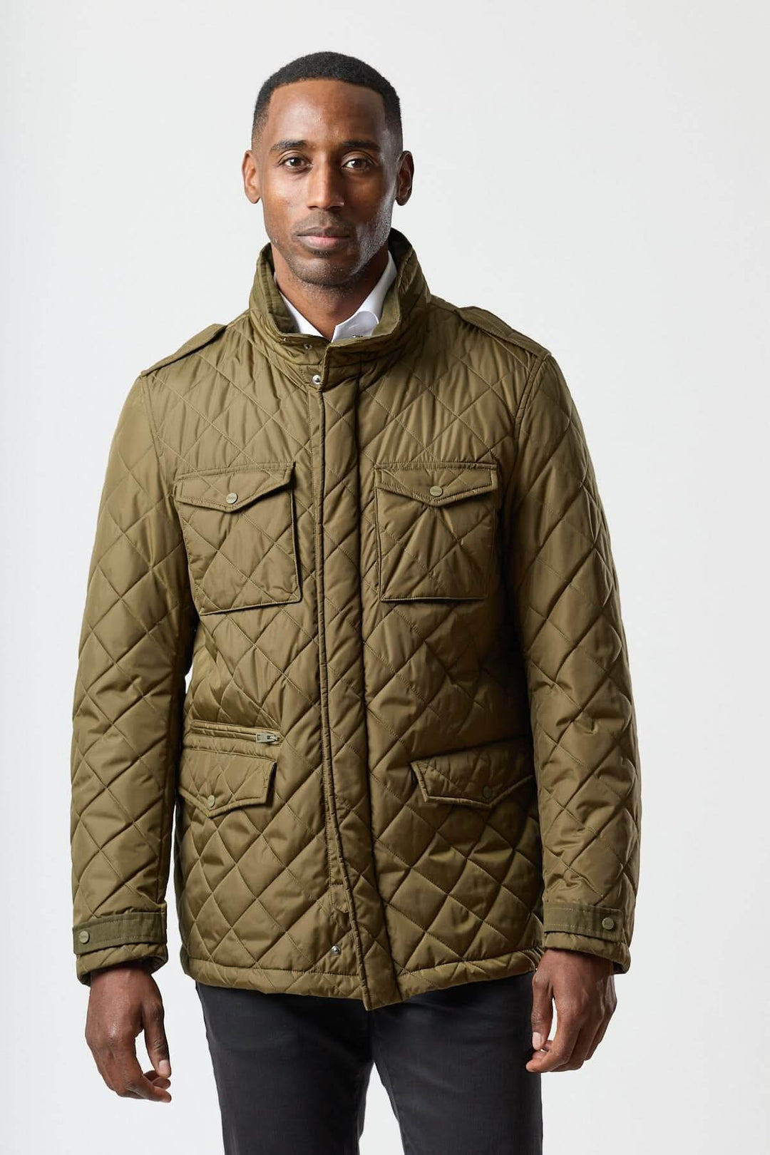 Homme portant une veste matelassée à capuche escamotable vert kaki, idéale pour un style smart-casual et coupe-vent.
