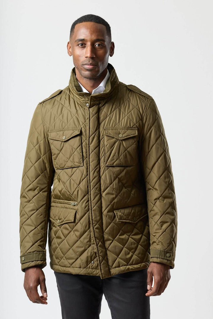 Homme portant une veste matelassée à capuche escamotable vert kaki, idéale pour un style smart-casual et coupe-vent.