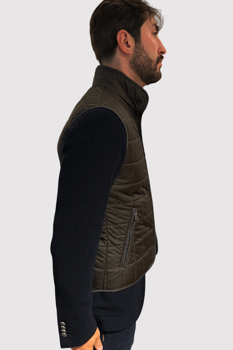 Homme portant une veste matelassée en nylon brun-kaki, idéale pour mi-saison, avec style et confort.