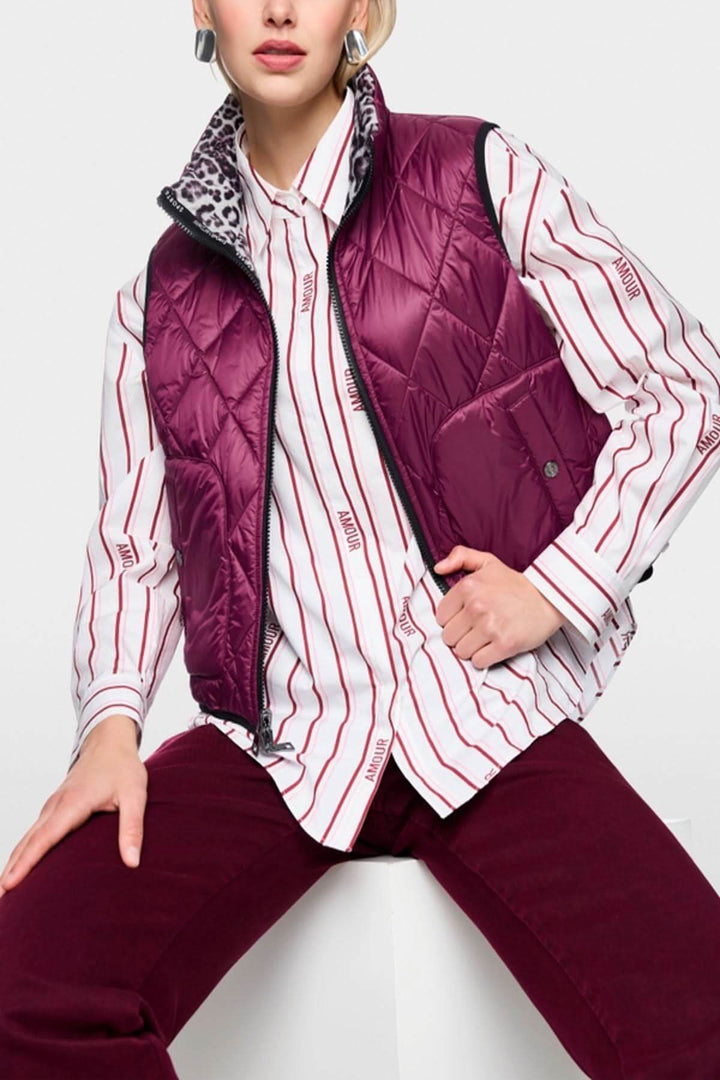 Veste sans manche réversible avec imprimé léopard et côté uni, fermeture éclair, poches latérales, et col montant, porté par un mannequin.