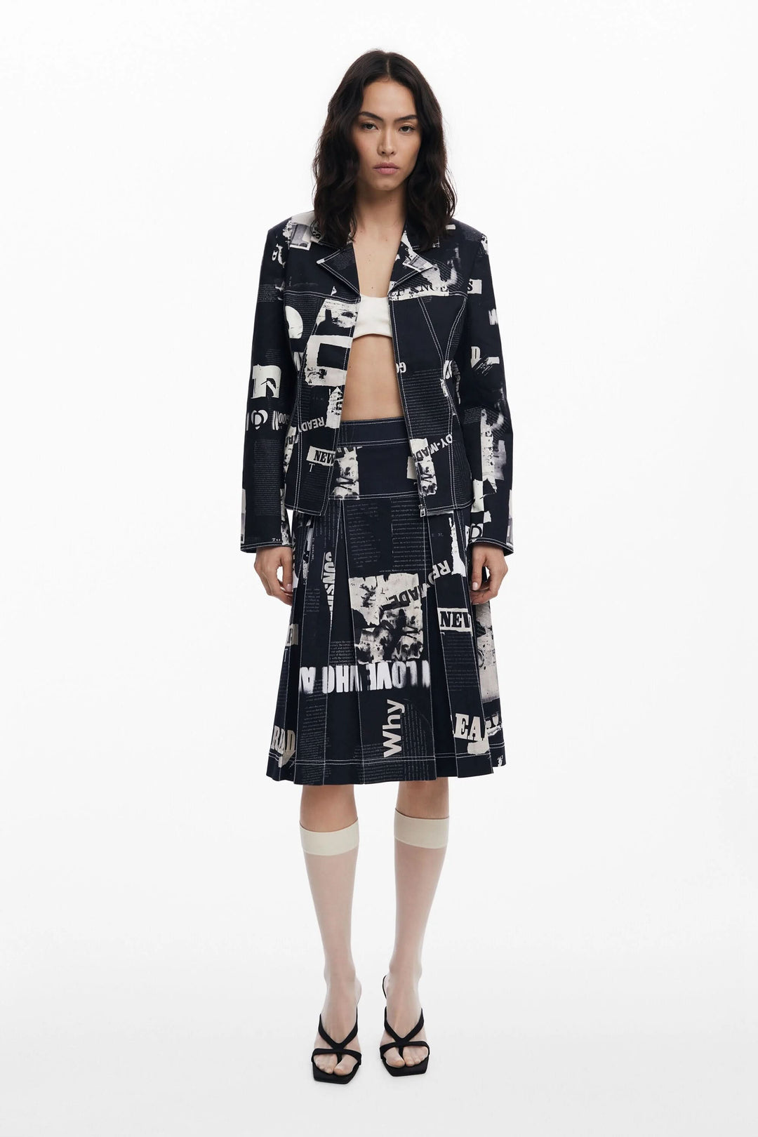 Femme portant une veste style motard imprimée typographique, idéal pour une allure audacieuse. Décris moi le produit en français.