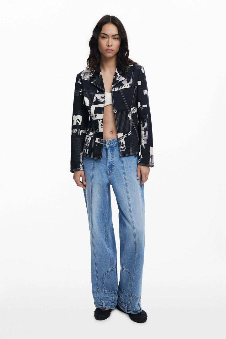 Veste style motard avec imprimé typographique, portée avec un jean large, pour un look audacieux et contemporain.