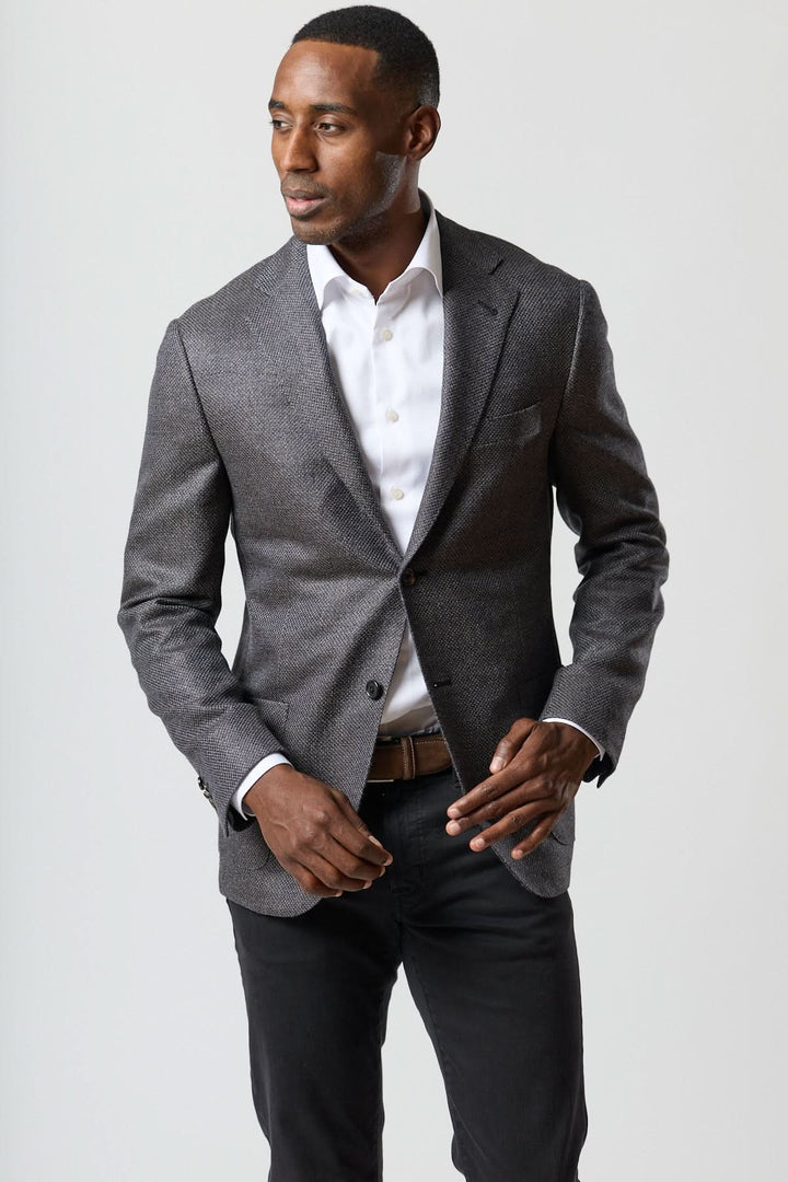 Homme portant un veston en laine mélangée marine et charbon de Corneliani, élégant et semi-ajusté, en laine, soie et cachemire.