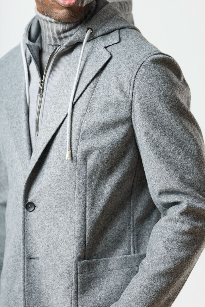Veston hybride à capuche gris avec capuche intégrée et col roulé pour un look urbain élégant.