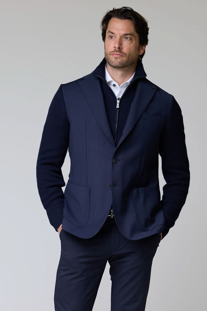 Homme portant un veston hybride tricot et tissu bleu pour un look sophistiqué et moderne.