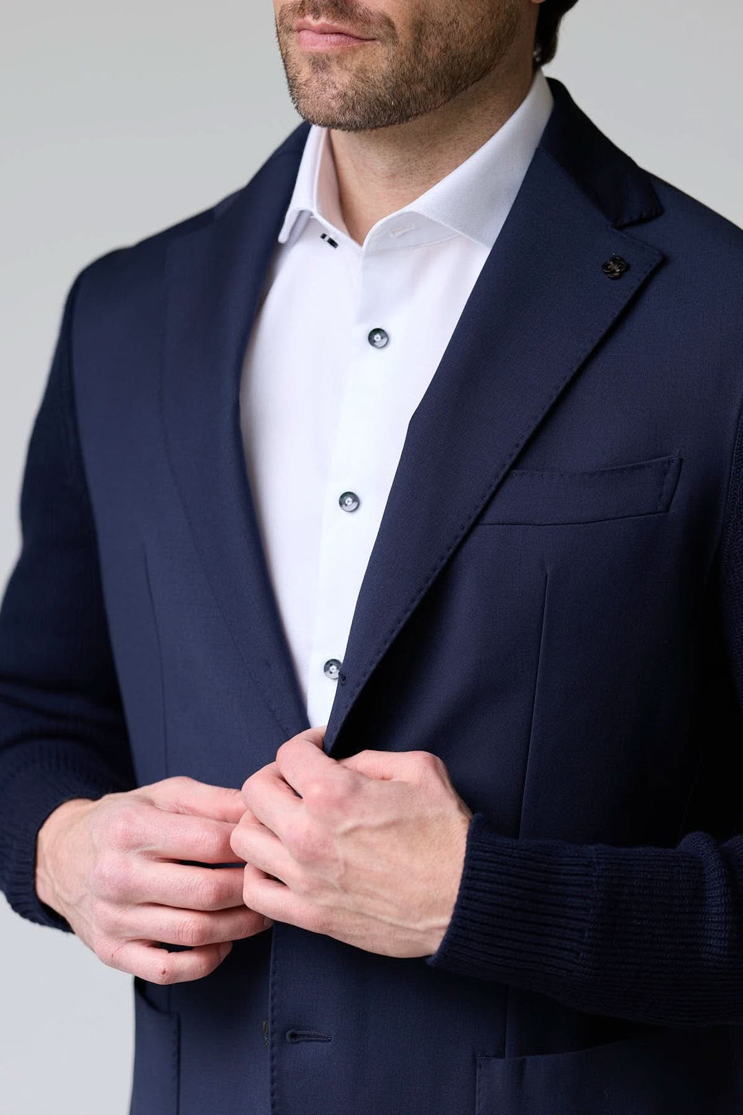 Veston hybride tricot et tissu élégant avec manches en maille, col à revers classique et fermeture à deux boutons, idéal pour un style chic.