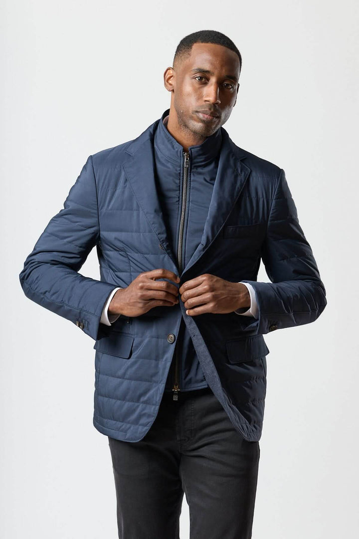 Homme portant un veston matelassé à encolure amovible signé Corneliani en bleu.