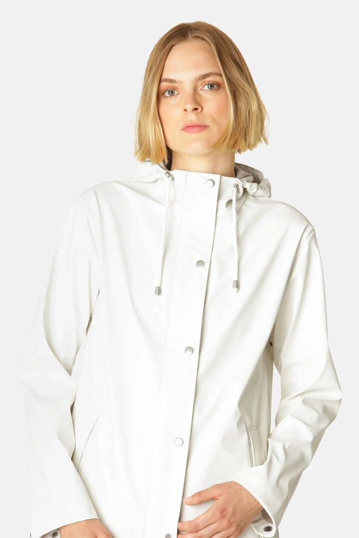 Femme portant un imperméable blanc à capuche, imperméable, moderne et durable, avec coutures soudées.