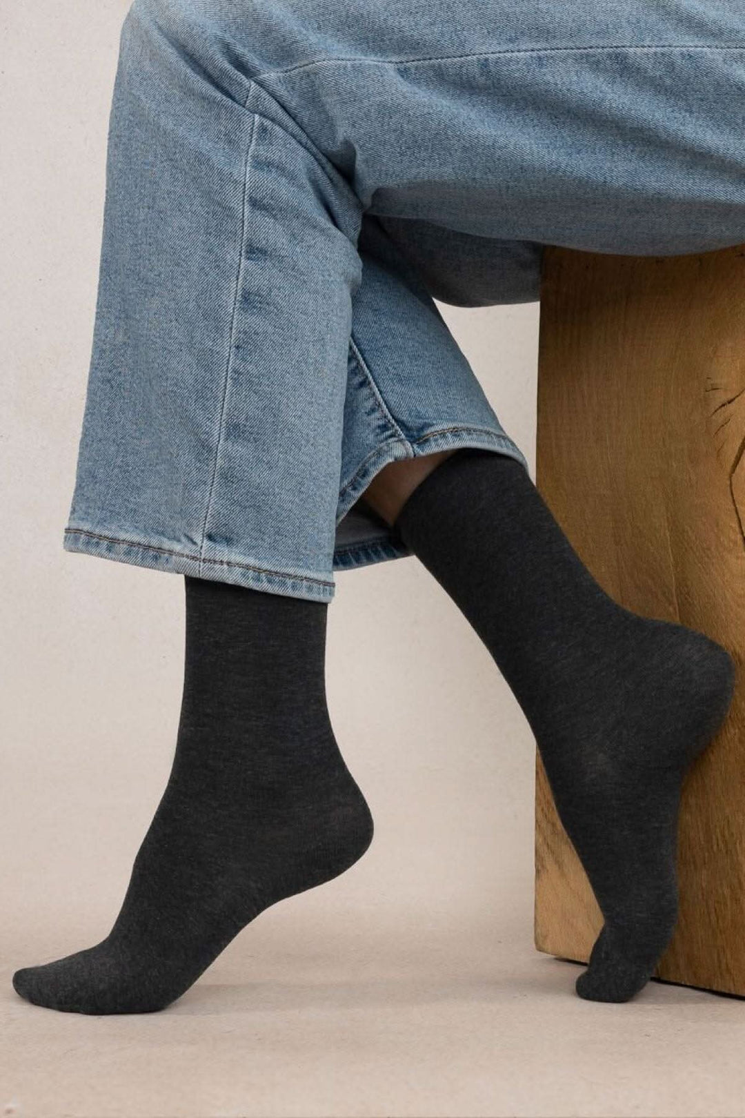 Chaussettes en coton noir porté avec un pantalon en denim, offrant confort et style.