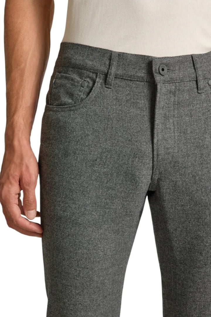 Jean en flanelle à coupe ajustée, gris, porté avec une chemise blanche, soulignant l'élégance et le confort du tissu texturé.