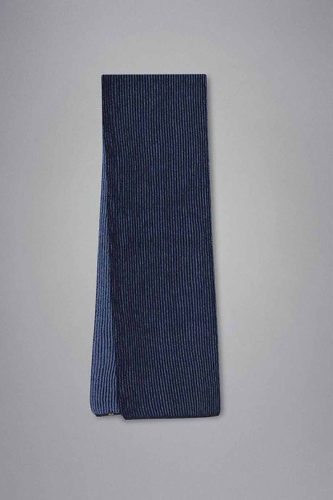 Écharpe en maille côtelée bicolore, texture douce, idéale pour l'hiver, à porter avec une tuque assortie.