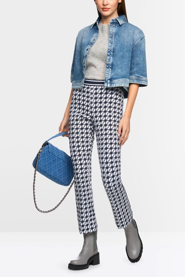 Femme portant un pantalon FREDERICA imprimé Cube avec une veste en jean et des bottines, tenue chic et moderne.