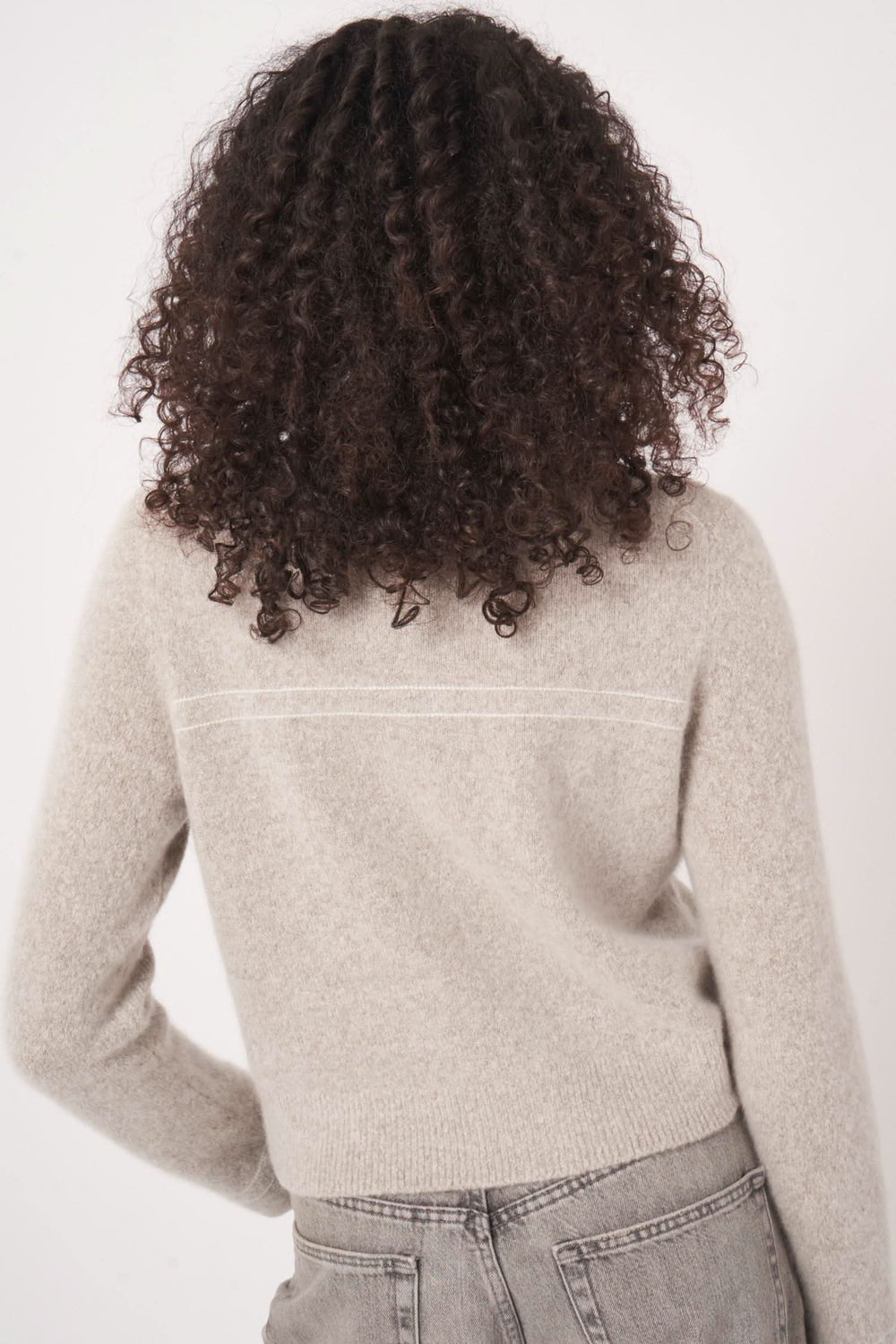 Femme avec cardigan en laine et cachemire, vue arrière, affichant sa texture douce et sa coupe élégante.