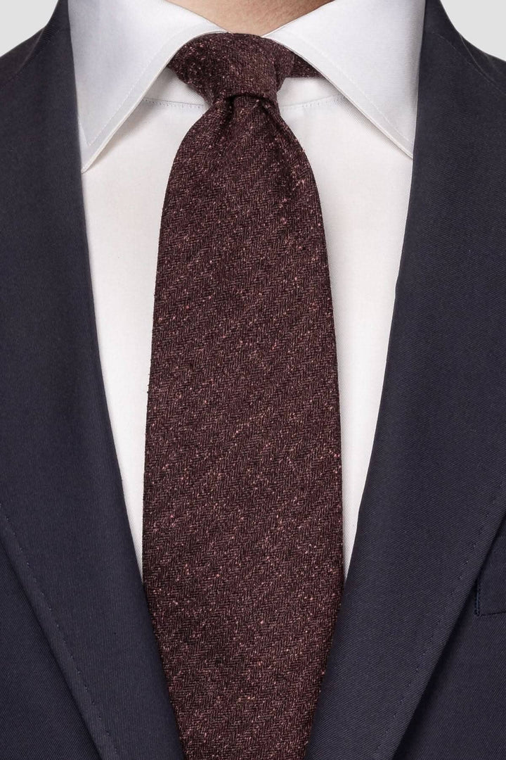 Cravate en soie rouge portée sur un costume élégant, alliant sophistication et modernité.
