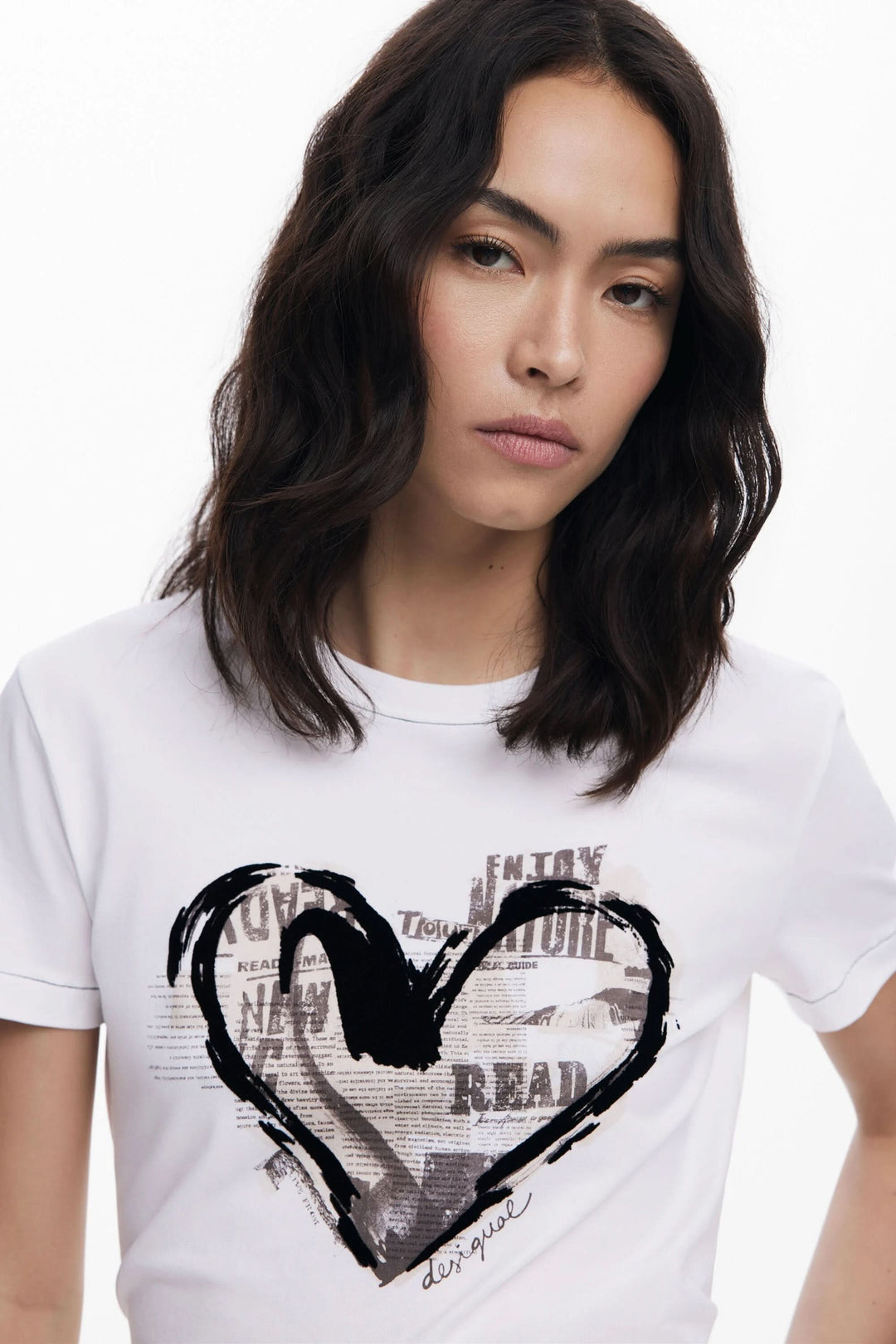 T-shirt à manches courtes avec un cœur graphique et d'éléments de collage sur fond blanc.