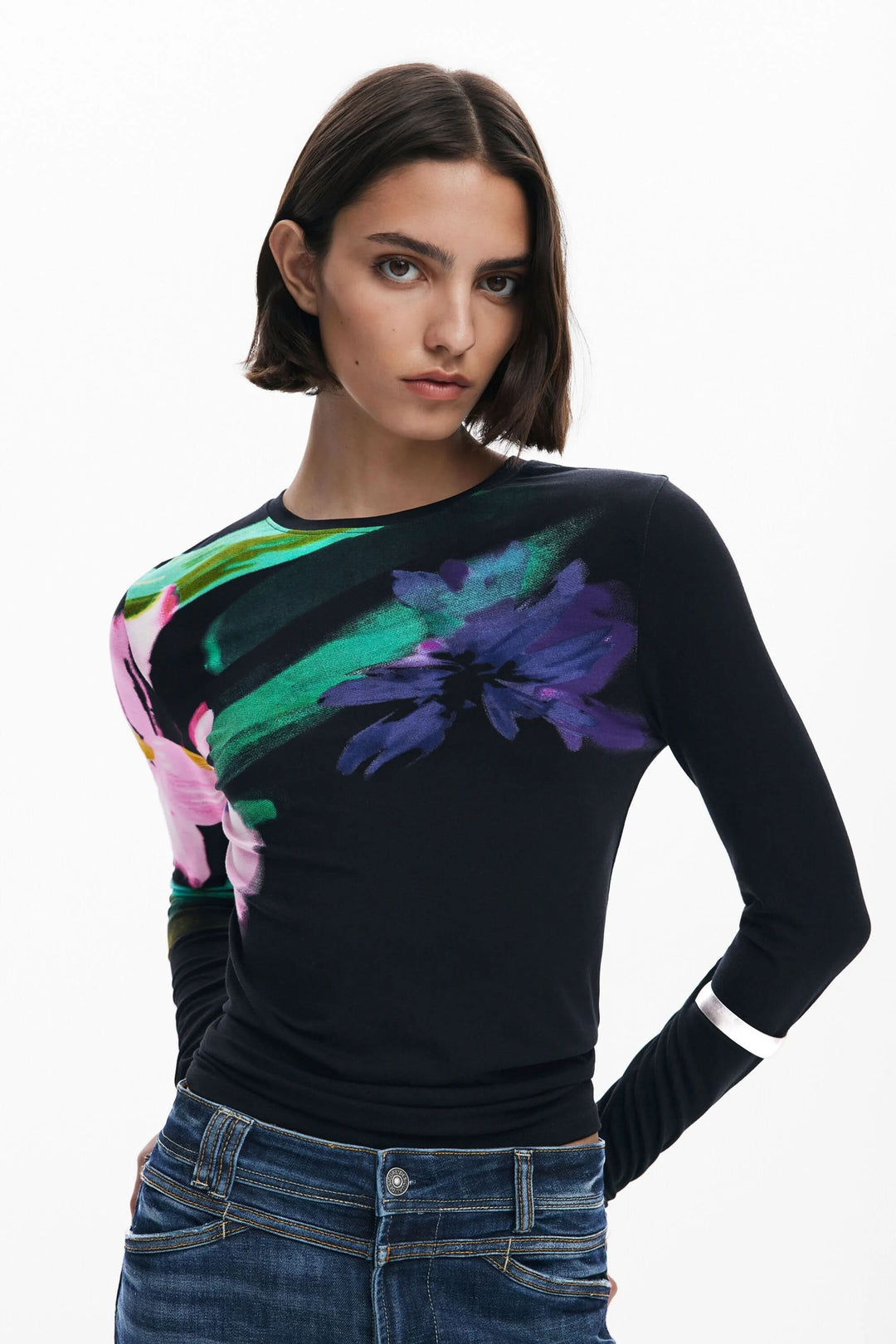 T-shirt floral à manches longues avec imprimé vibrant sur fond sombre, porté par un modèle.