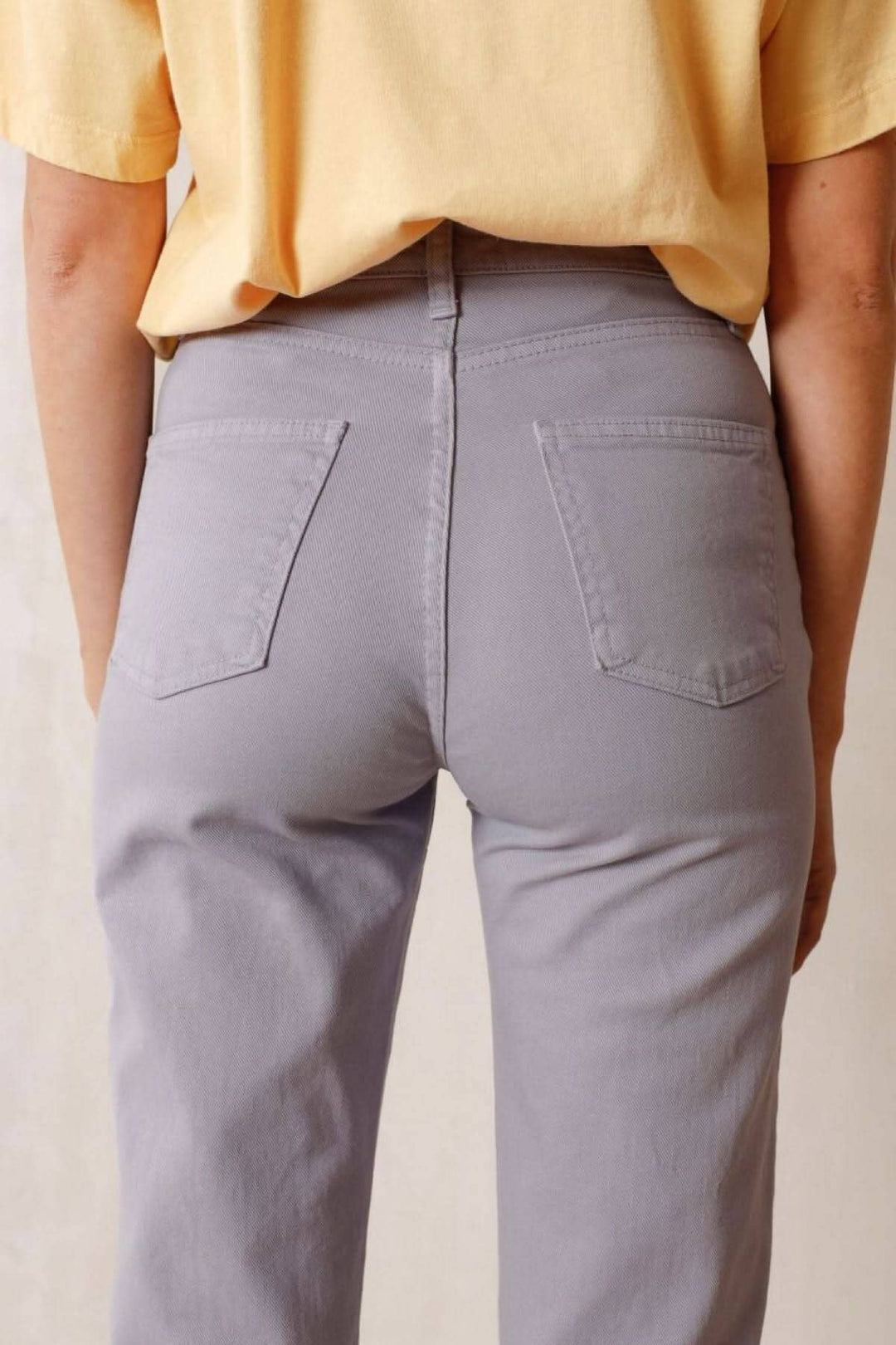 Pantalon Harry à taille haute, ajusté, en coton, avec poches, porté avec un t-shirt jaune.