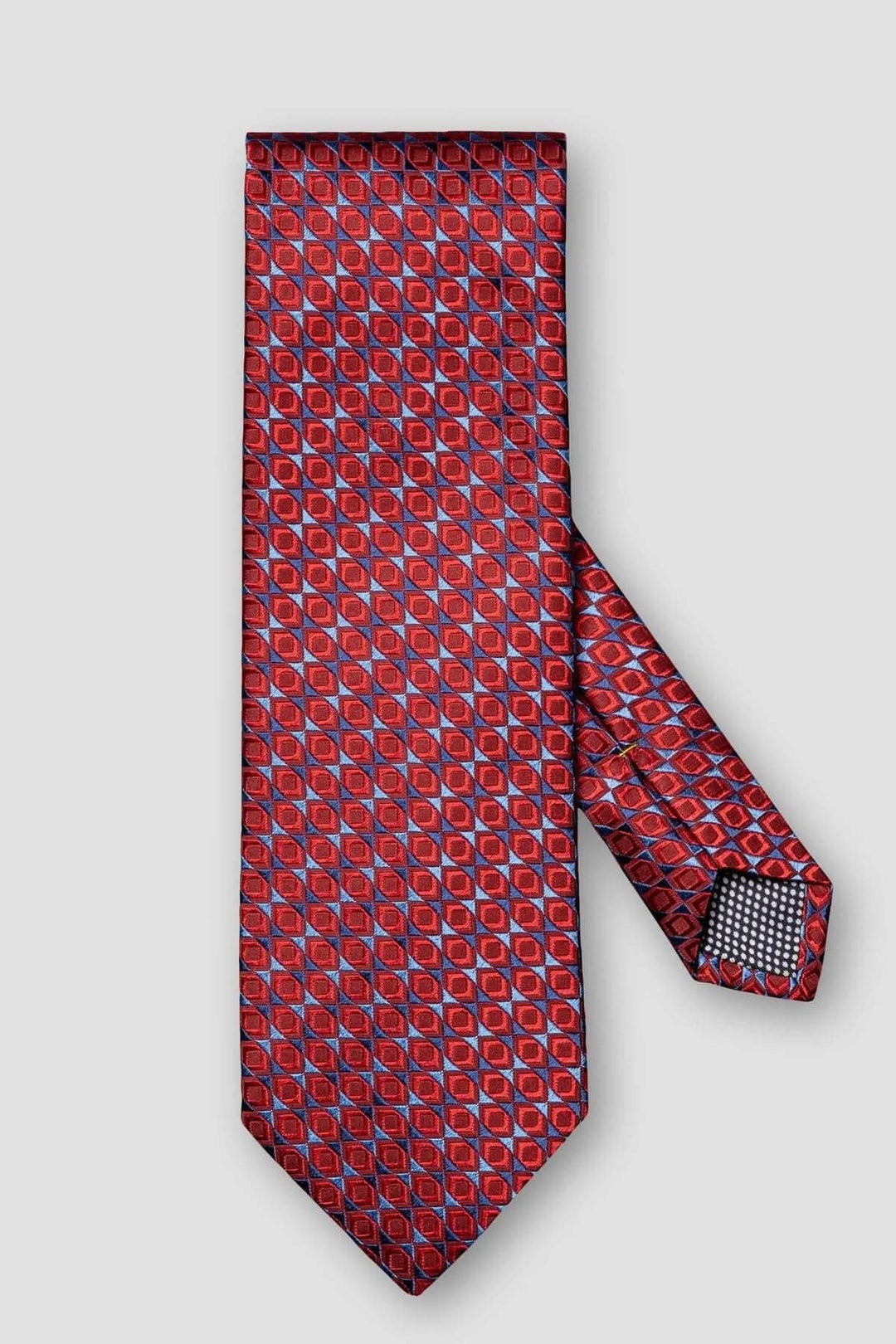 Cravate de soie Eton avec motif géométrique rouge et bleu, élégante pour les tenues formelles.