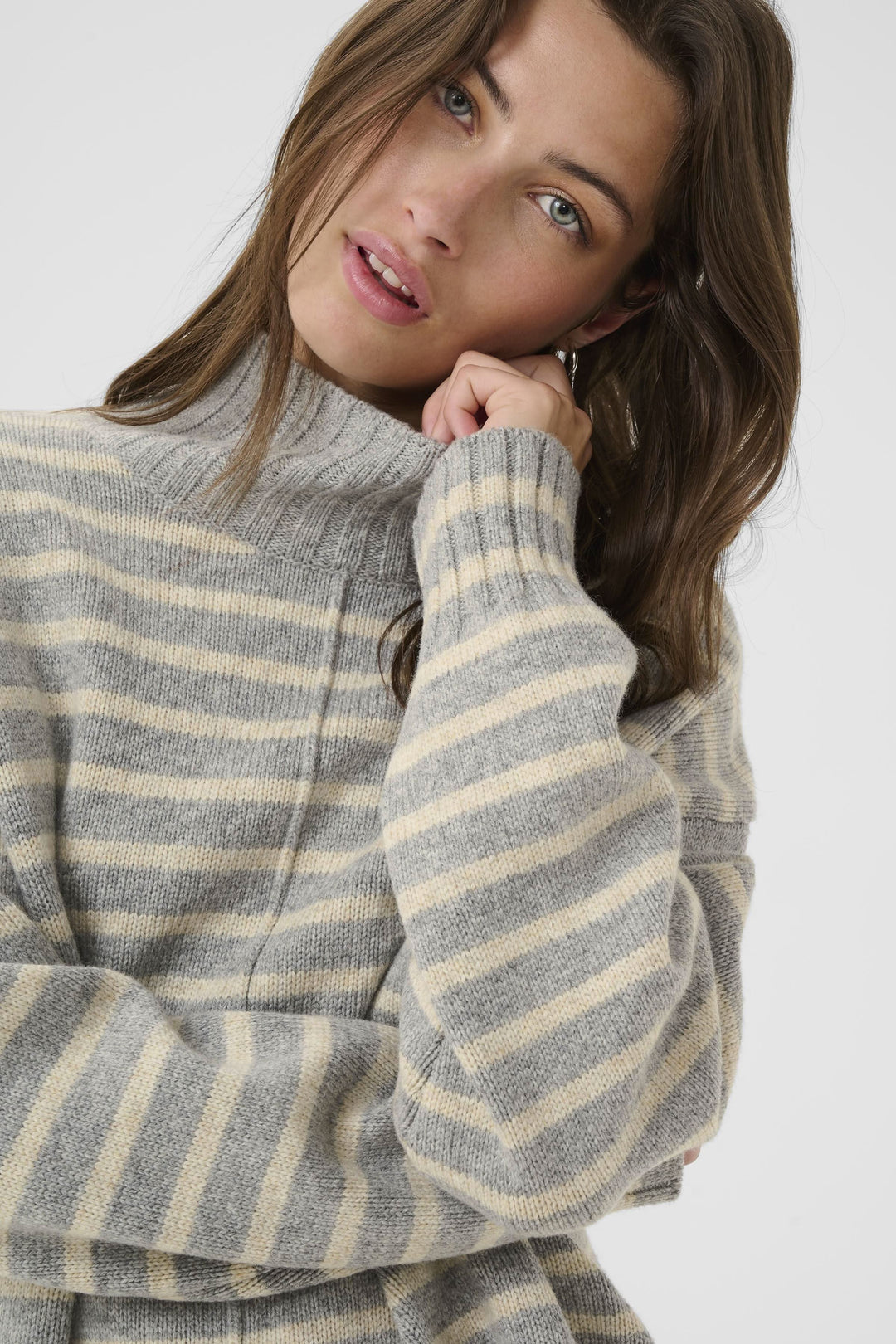 Tricot à col montant rayé en beige et gris, parfait pour un style décontracté et élégant.