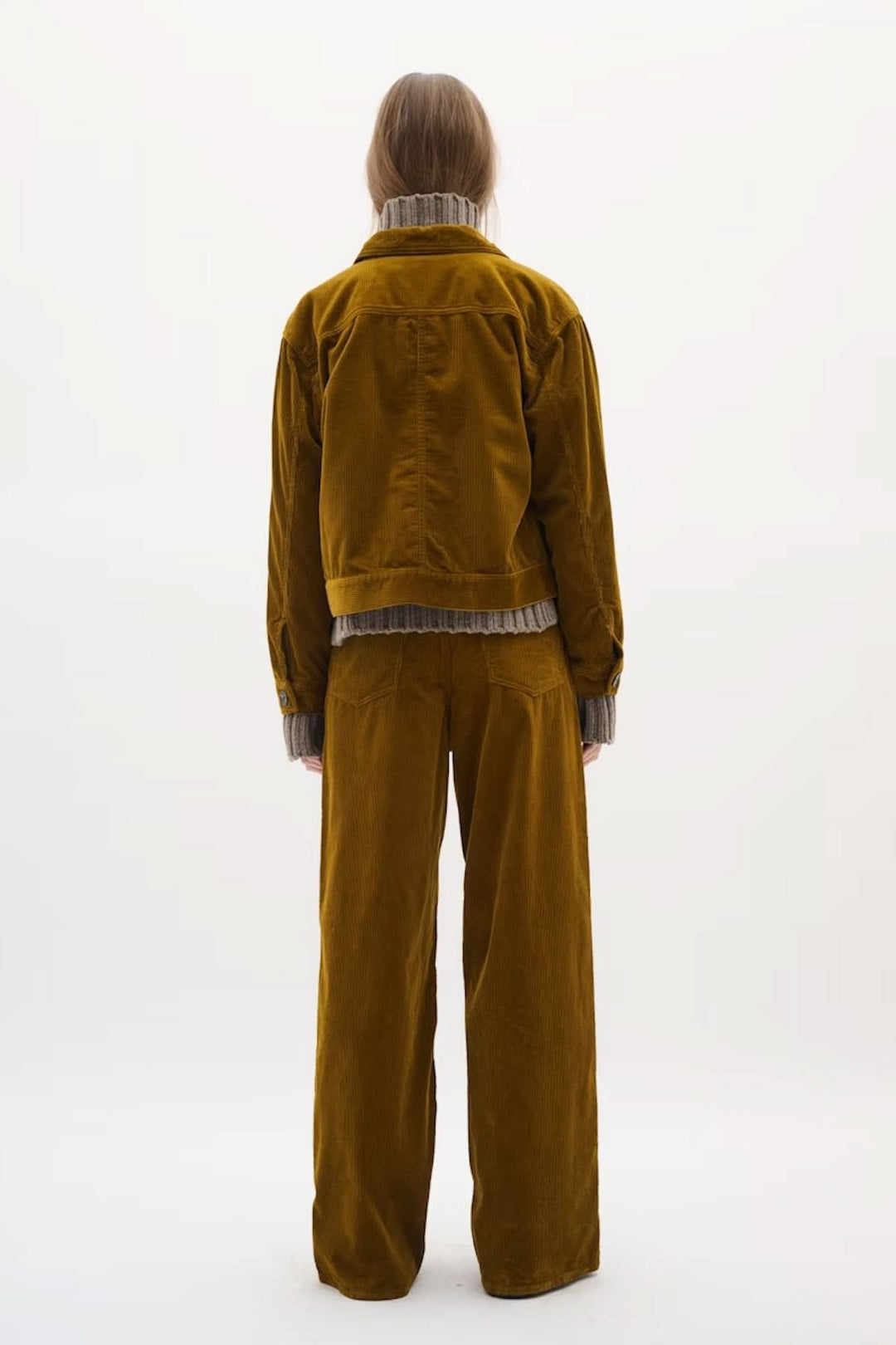 Veste en velours côtelé marron, vue de dos, portée avec un pantalon assorti pour un look monochrome tendance.