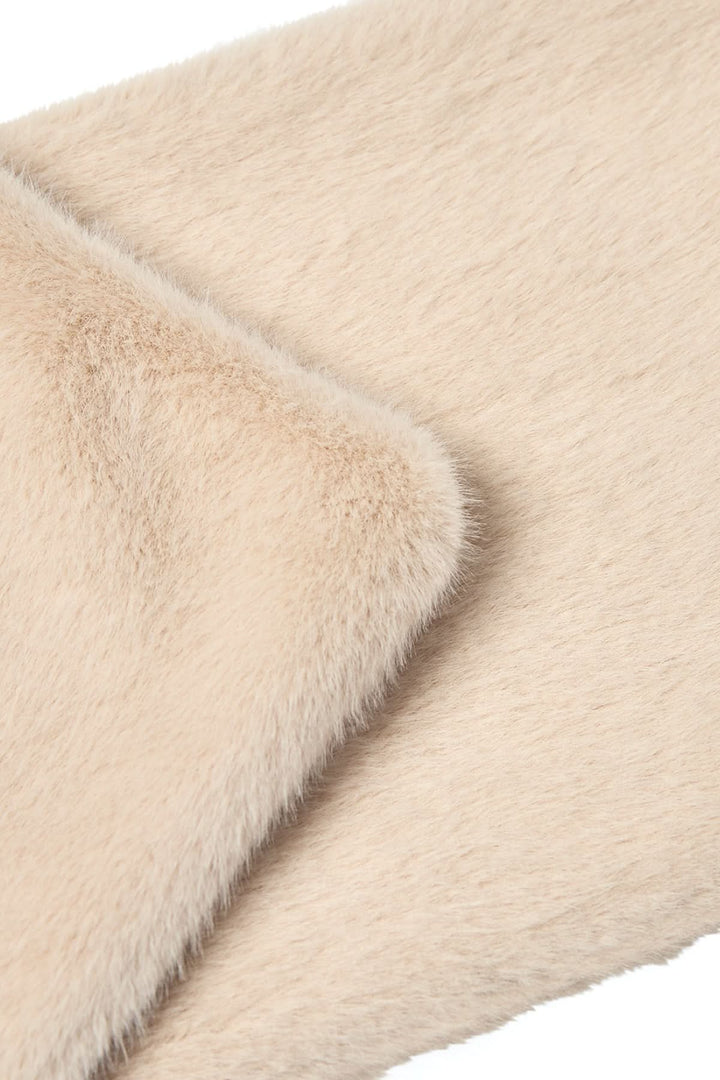 Texte close-up d'un foulard en fausse fourrure douce, couleur beige, montrant sa texture peluche.