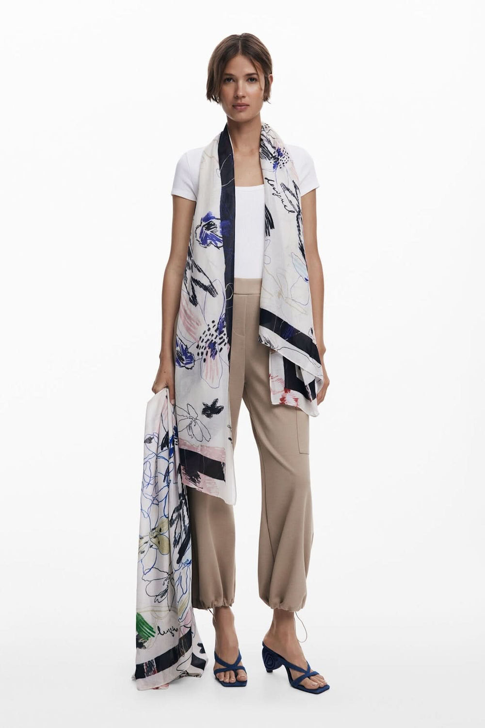 Foulard illustré en tissu fluide avec imprimé floral, porté élégamment pour un look contemporain.