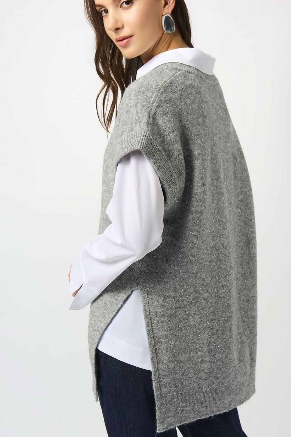 Débardeur en tricot gris avec paillettes, coupe ample, porté sur chemise blanche pour un look automne-hiver.