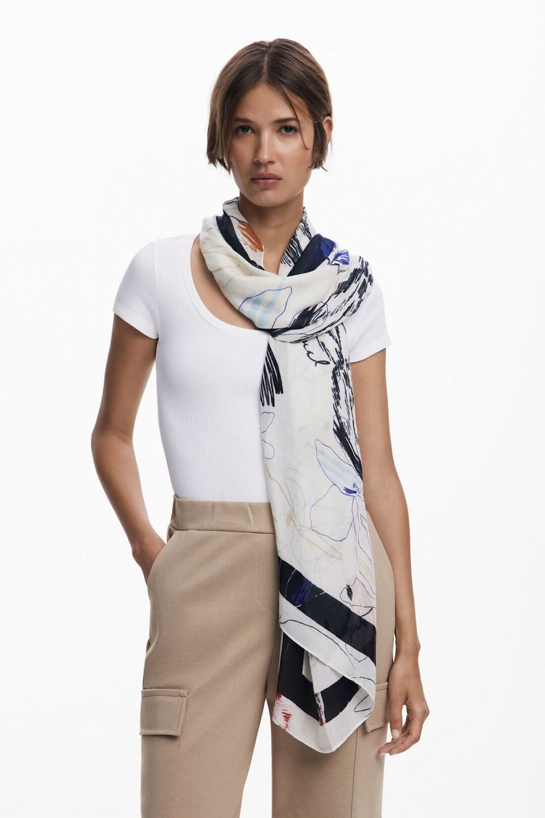 Foulard illustré en tissu fluide avec motifs floraux, porté élégamment autour du cou par une femme.