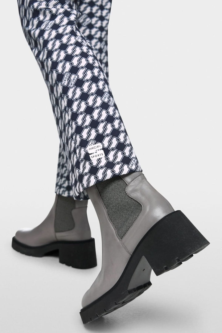 Pantalon FREDERICA imprimé Cube graphique avec bottines grises à talon haut.