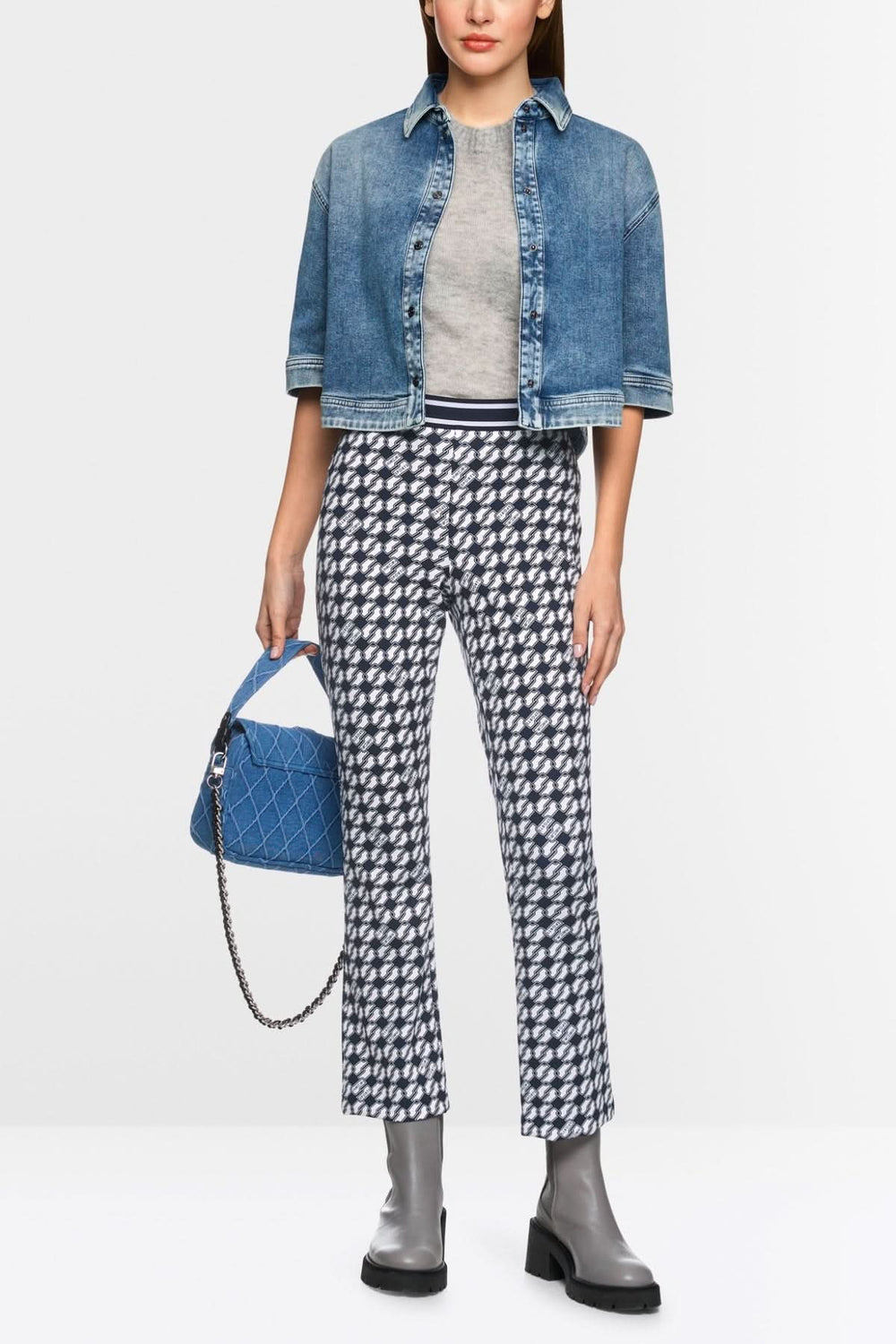 Femme portant pantalon FREDERICA imprimé Cube avec haut gris et veste en jean, accessoire sac bleu.