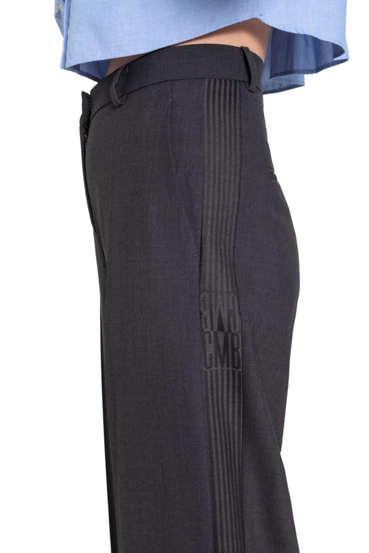 Pantalon Glam Slouch noir à jambe large avec détail rayé ton sur ton, porté avec une chemise bleue.