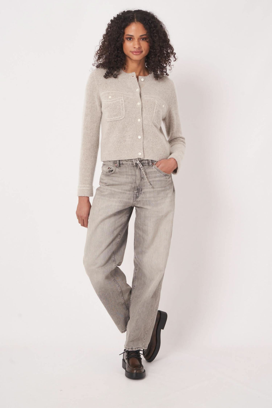 Cardigan en maille gris avec poches plaquées, porté par une femme, idéal pour les looks décontractés.