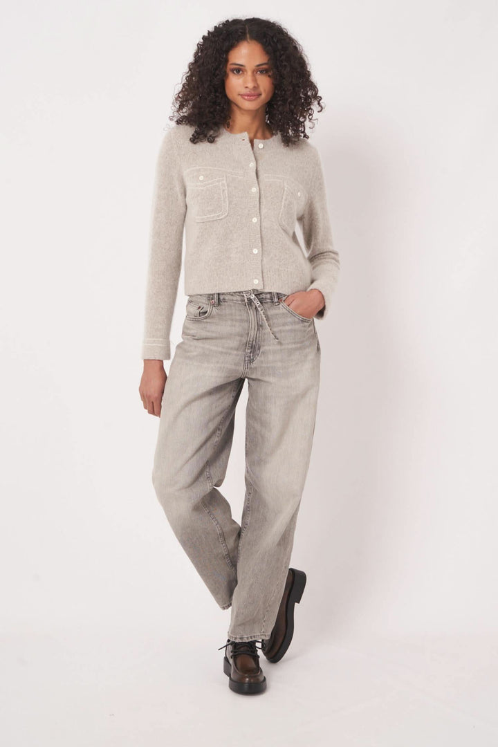 Cardigan en maille gris avec poches plaquées, porté par une femme, idéal pour les looks décontractés.