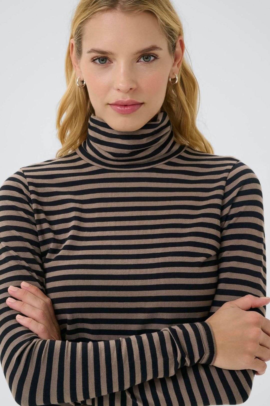 Femme portant un Col roulé Efinas rayé noir et beige, coupe ajustée, manches longues, style élégant et polyvalent.