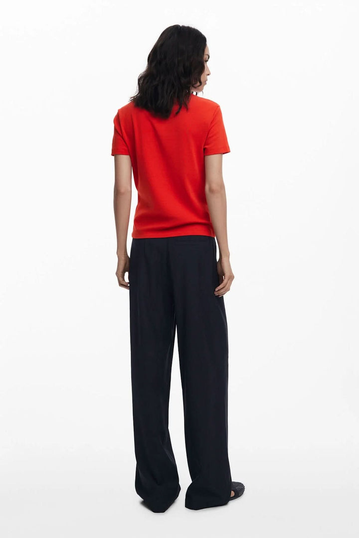 T-shirt illustré rouge à manches courtes, porté avec un pantalon noir, vue de dos, style décontracté.