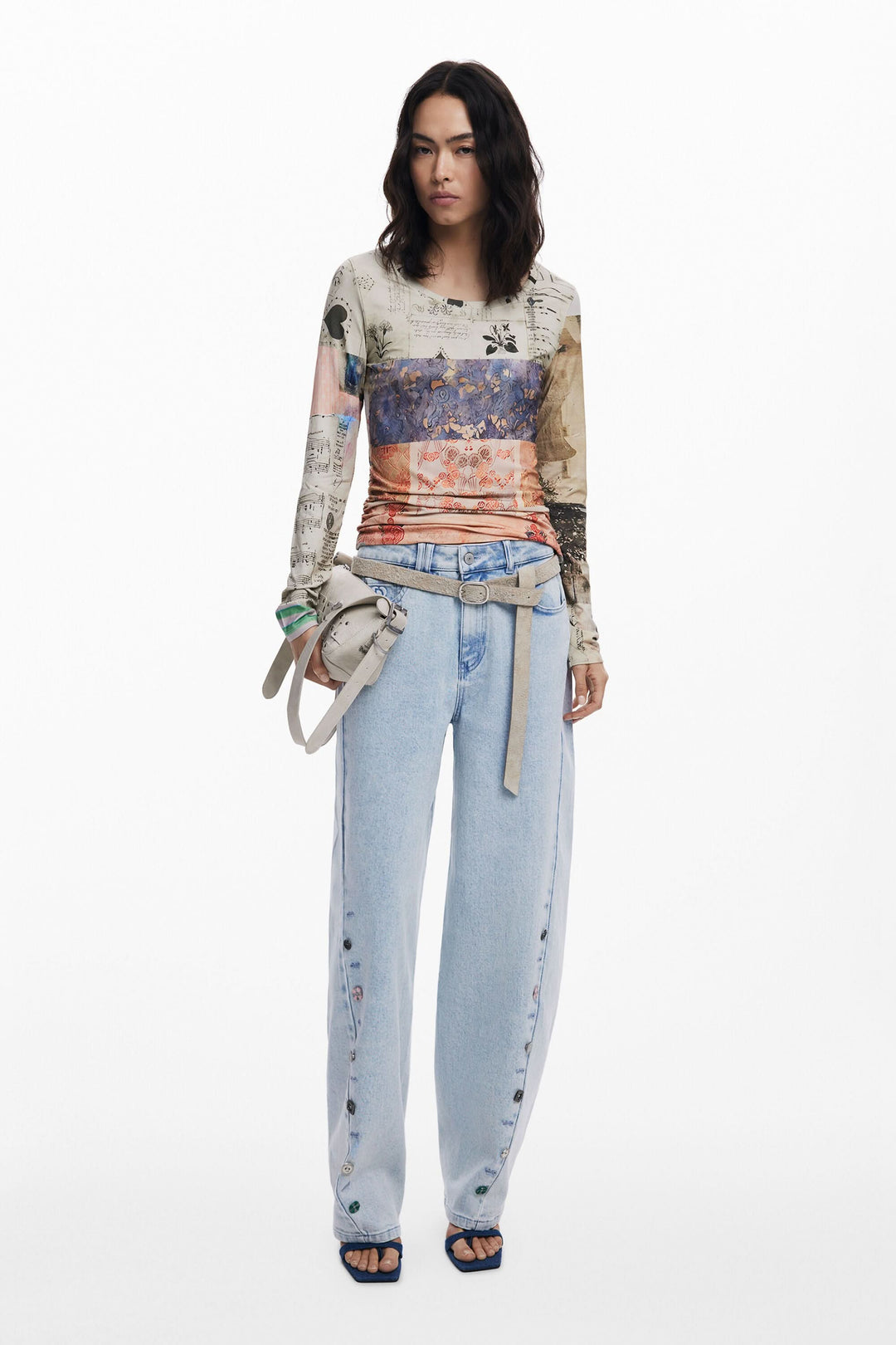 Femme portant un t-shirt à manches longues imprimé patchwork et un pantalon en denim clair.