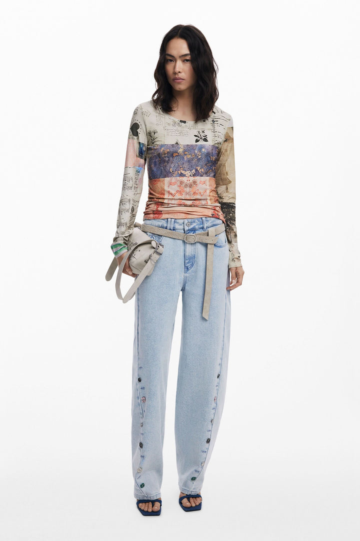Femme portant un t-shirt à manches longues imprimé patchwork et un pantalon en denim clair.