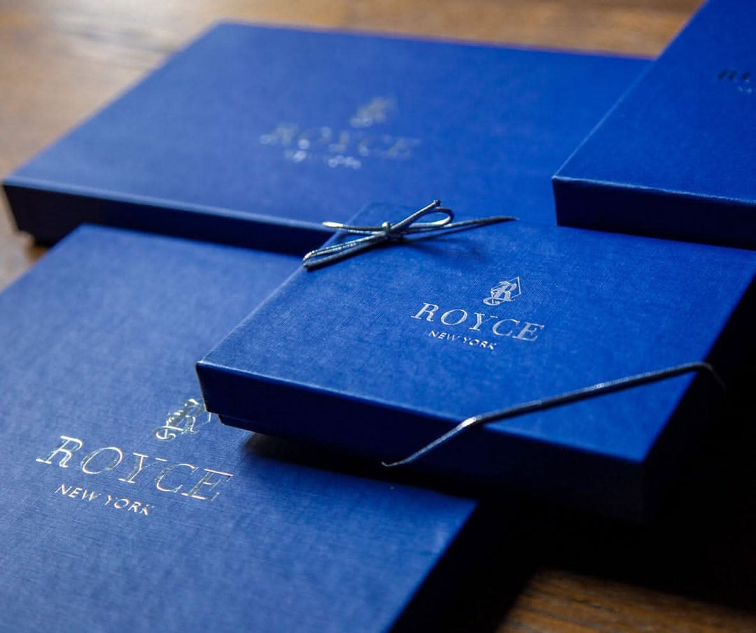 ROYCE New York elegant blue gift boxes with gold logo for luxurious packaging.
