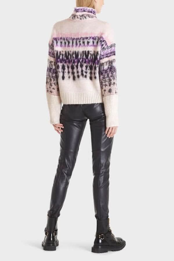 Chandail alpin en laine avec motifs colorés, porté avec un pantalon en cuir noir.
