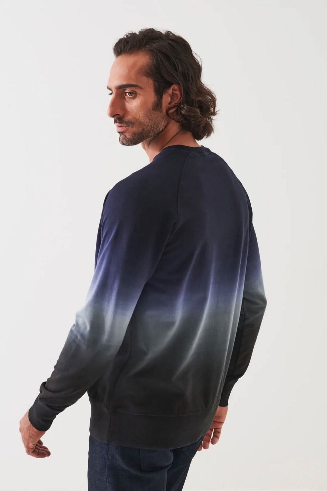 Homme portant un col rond en coton dégradé, vue de dos, avec un design moderne et élégant.