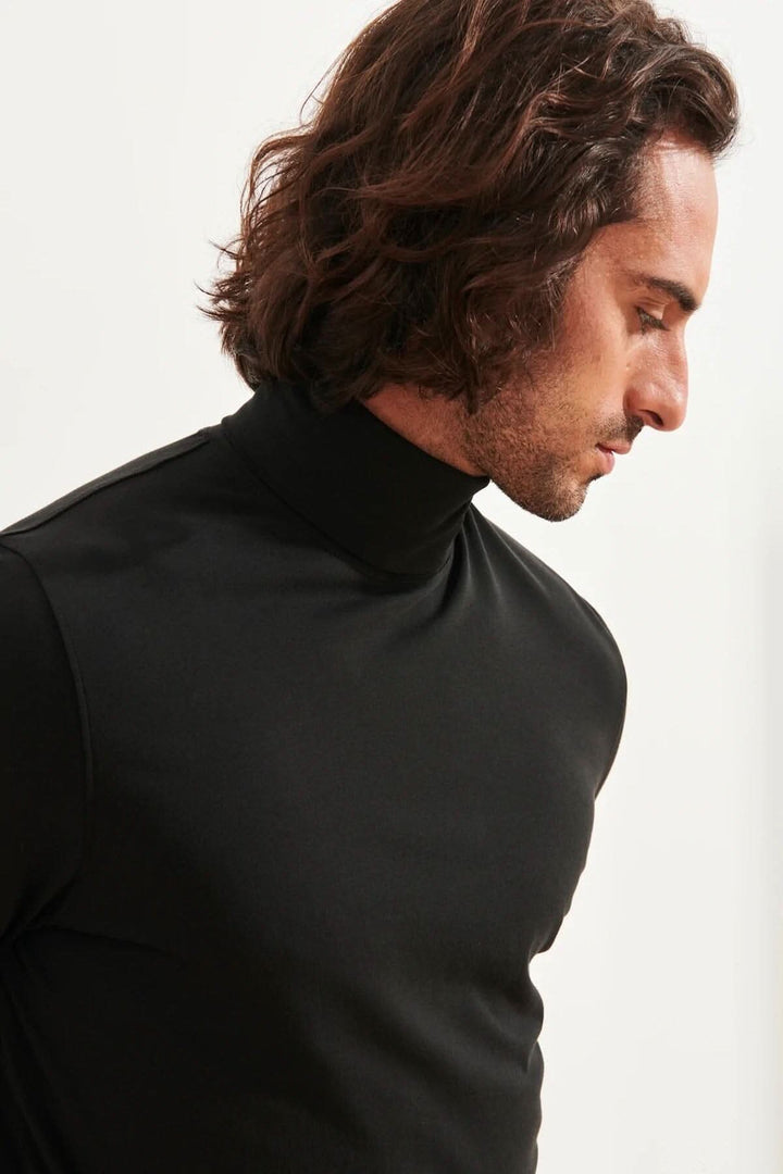 Homme portant un col roulé stretch en coton pima noir, offrant confort et style polyvalent.