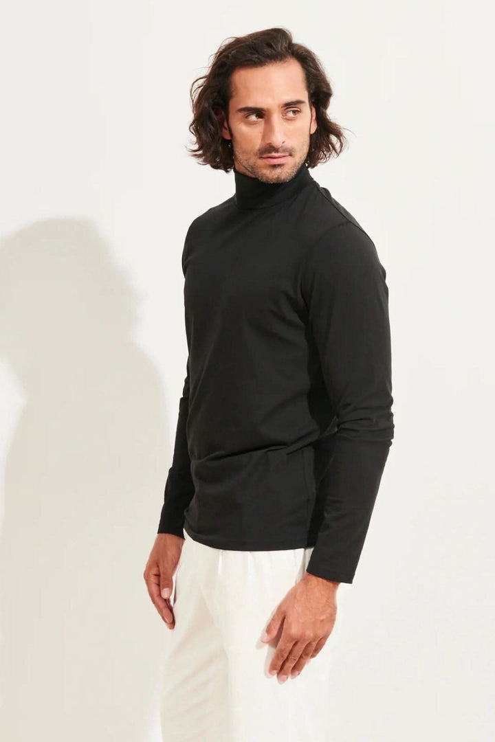 Homme portant un col roulé stretch en coton pima noir, offrant confort et élégance.